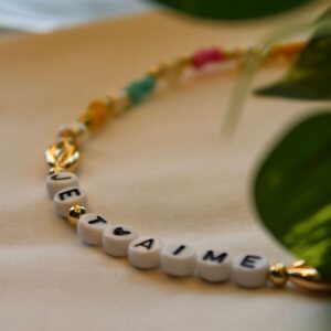 Close-up of a personalized beaded bracelet with 'JE T'AIME.'